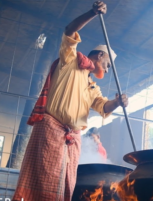 Bind Catering chef stirring a traditional cooking pot over an open flame